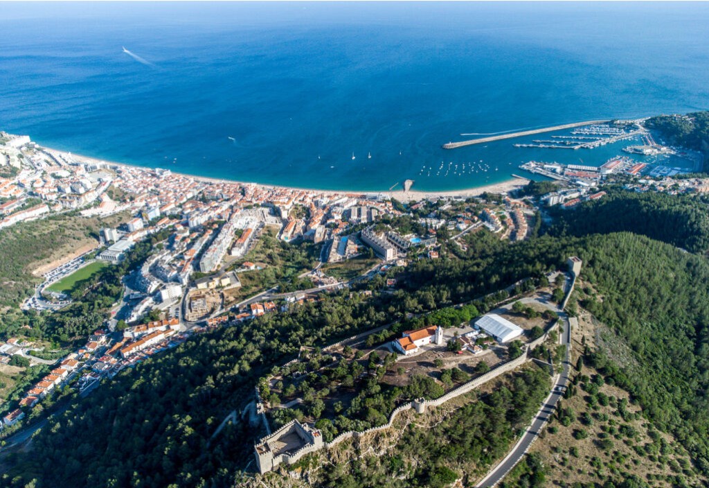 Vista aérea de Sesimbra com o castelo, a vila e a baía